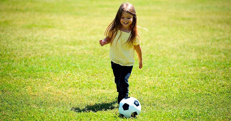 Niña jugando con una pelota de fútbol